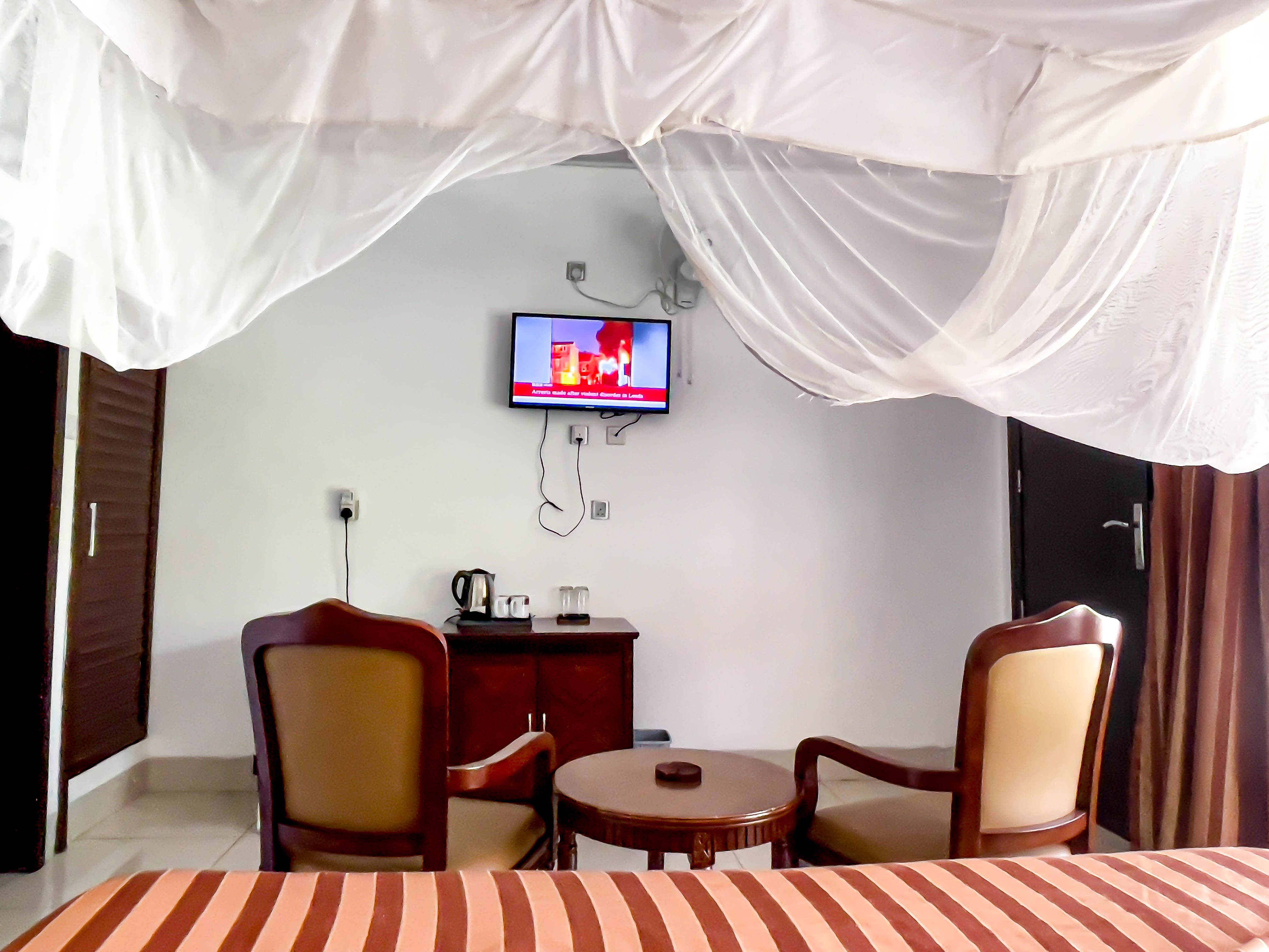 close up front view of room with 2 sofas outside and room number on door